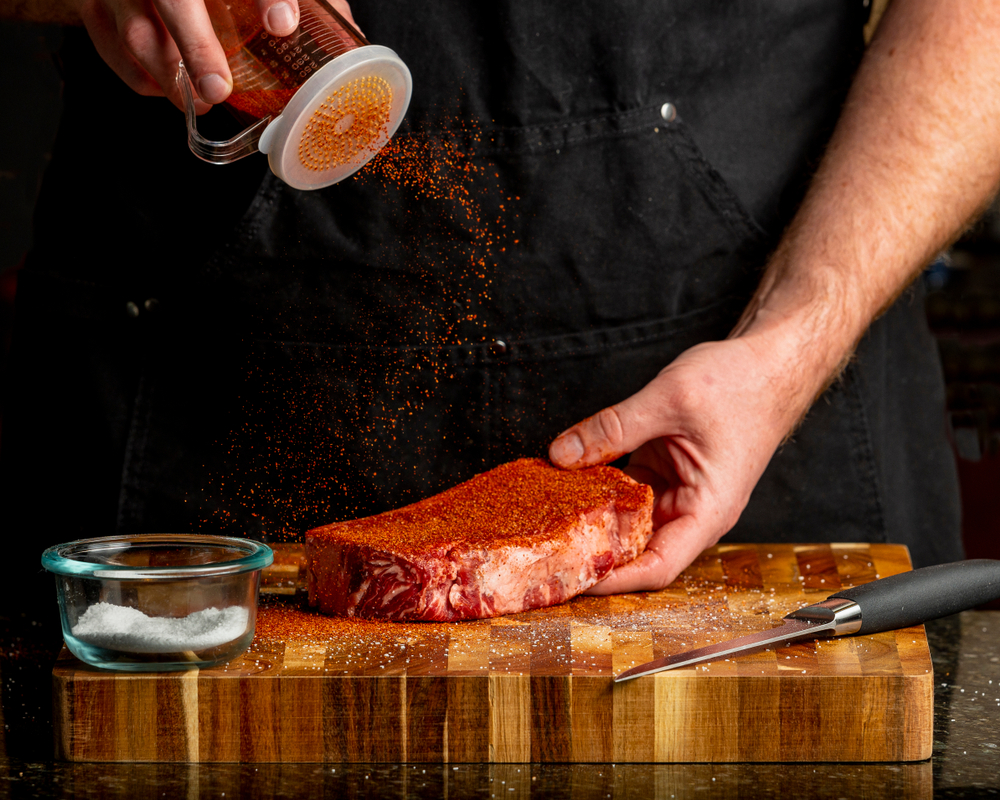 Man Rubbing Steak With Steak Rub